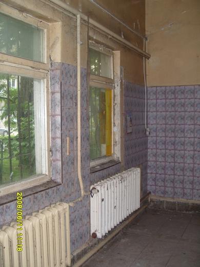 Stare okna i zdemontowane grzejniki przed remontem